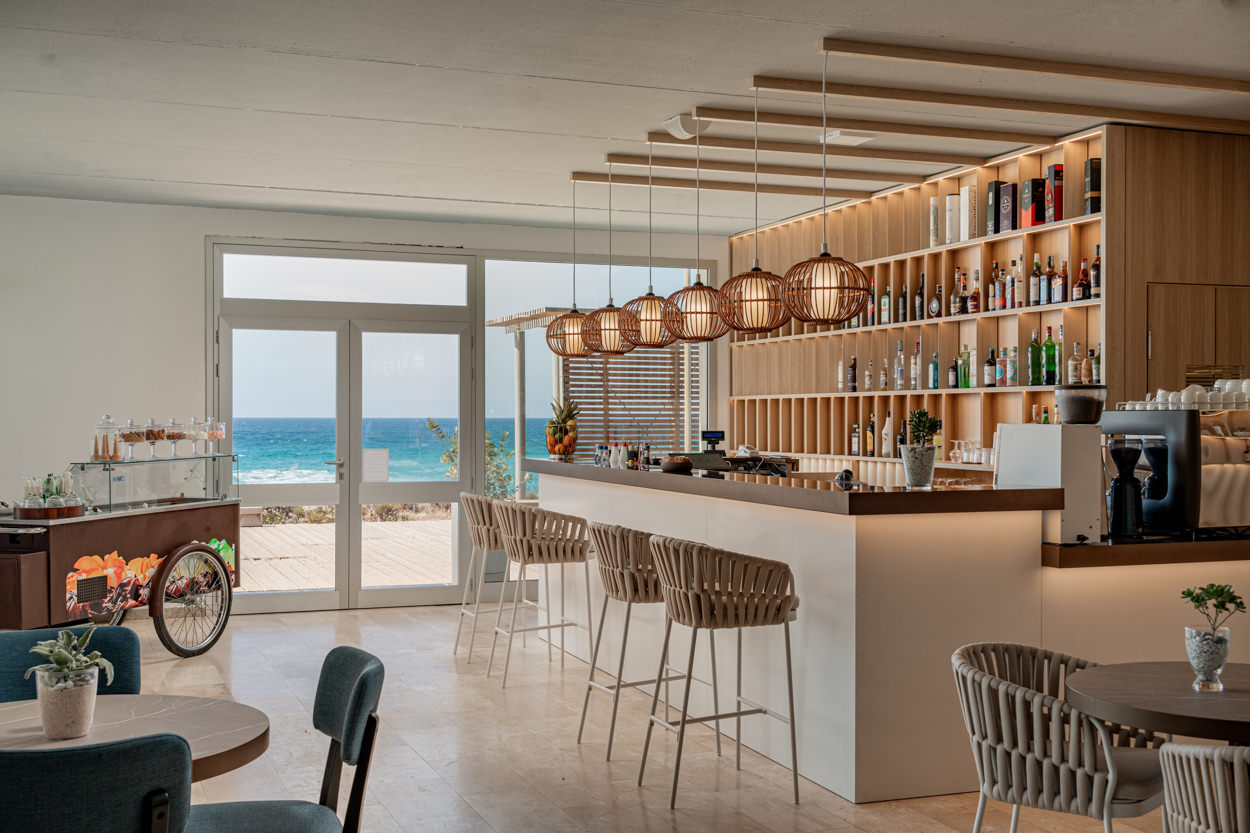 Angolo bar con carrello gelati e vista mare, fotografato da un fotografo specializzato in hotel a Castiadas. Immagine che mostra l'eleganza del bar e la splendida vista panoramica sul mare.